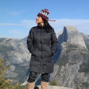 Woman standing in Yosemite, with Half Dome in the background.